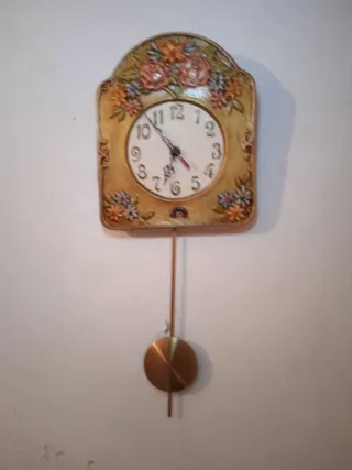 Reloj de pared con péndulo dorado