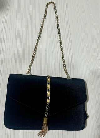 Bolso d mano negro con detalles dorado.Un solo uso