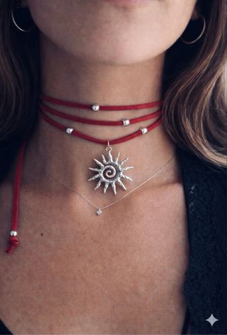 Choker scamosciato bordeaux con ciondolo sole