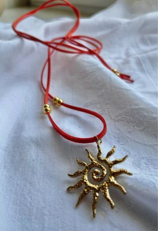 Choker scamosciato arancione con ciondolo sole oro