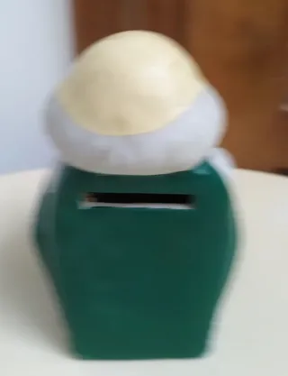 Hucha cerámica anciano sentado leyendo, mide 12 cm