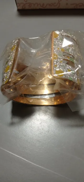 Pulseras doradas con puntos verdes y amarillos