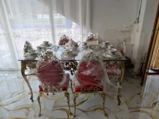 Mesa de cristal con juego de vajilla y sillas