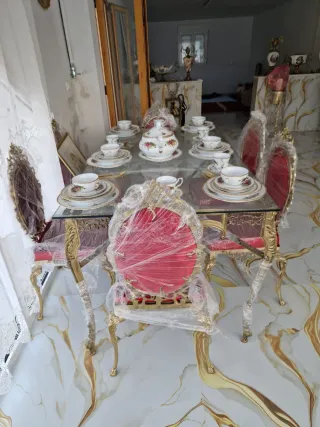 Mesa de cristal con juego de vajilla y sillas