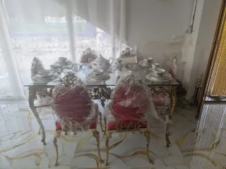 Mesa de cristal con juego de vajilla y sillas