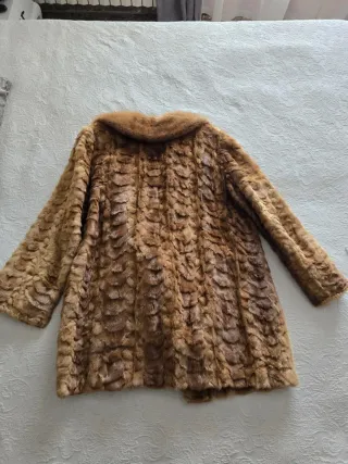Abrigo de piel marrón, tiene un pequeño descosido