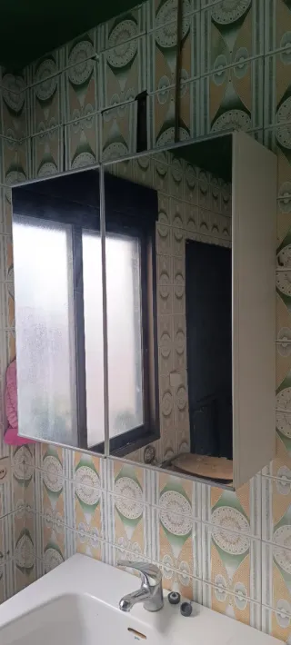 Mueble de baño blanco con espejos y estantes.