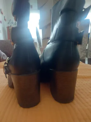 Botas con cremallera y hebillas doradas.