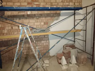 Carretilla de albañil y andamio