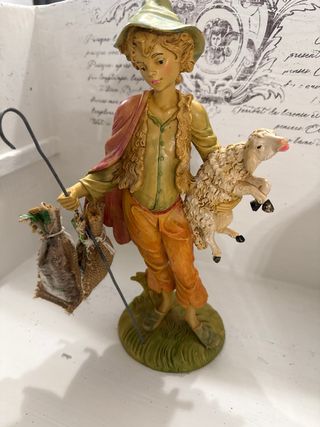 Statua pastore con pecora e sacchi