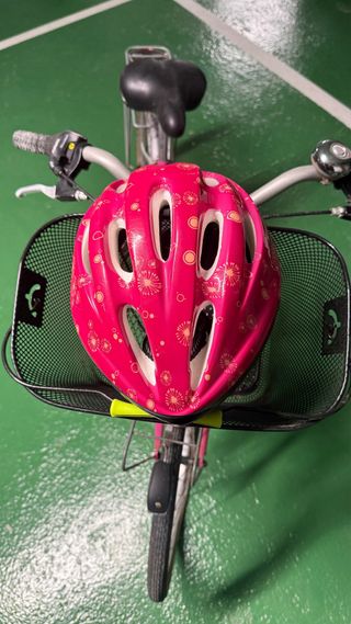 Bicicletta rosa con cestino, lucchetto e casco