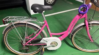 Bicicletta rosa con cestino, lucchetto e casco