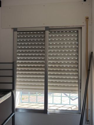 Ventana con persiana y mosquitera Una puerta