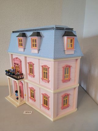 Casa de muñecas rosa con figuras
