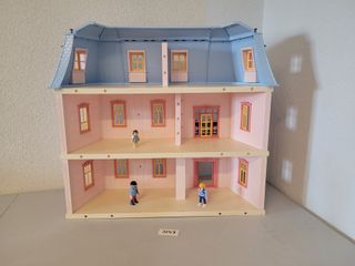 Casa de muñecas rosa con figuras