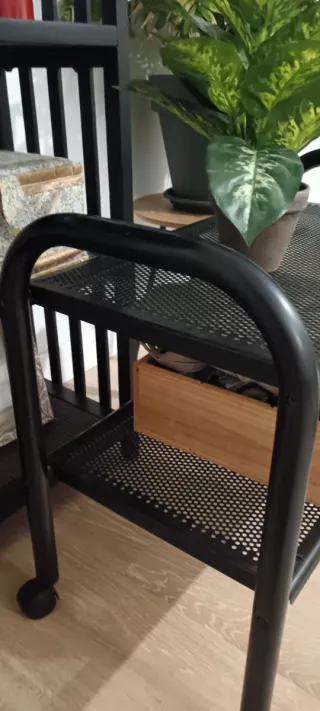 Carrito auxiliar metálico negro con ruedas.