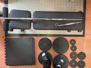 Banco de gimnasio con pesas y esterillas