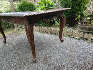 Mesa de comedor extensible de madera tallada.