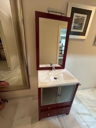 Mueble de baño rojo con lavabo y grifo