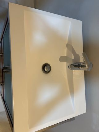 Mueble de baño rojo con lavabo y grifo