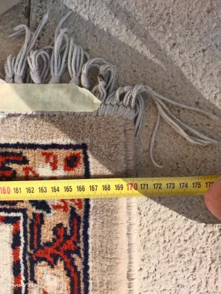 Alfombra beige y roja de tela