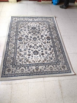 Alfombra beige y gris con diseño floral