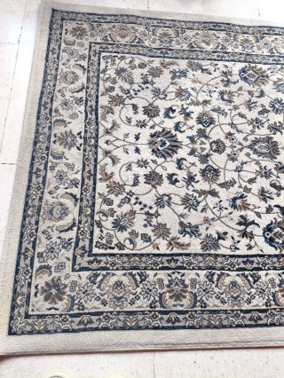Alfombra beige y gris con diseño floral