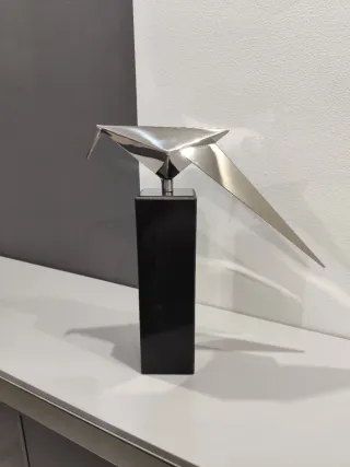 Pie de mármol y ave de acero inoxidable