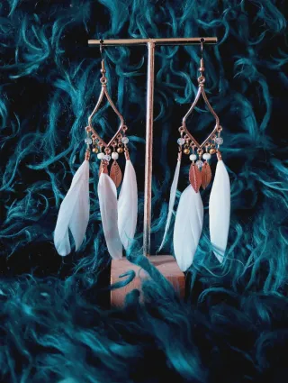 Pendientes de plumas dorados y blancos