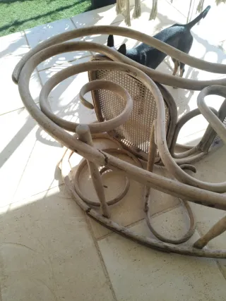 Vecchia sedia a dondolo in rattan e legno