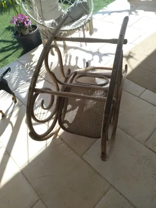 Vecchia sedia a dondolo in rattan e legno