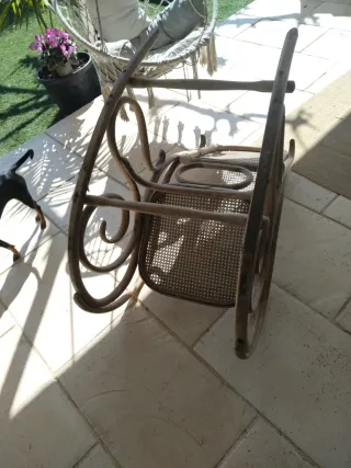 Vecchia sedia a dondolo in rattan e legno