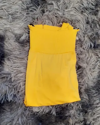 Camiseta amarilla con cremalleras.