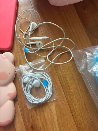 iPhone X blanco con fundas, cargador y auriculares