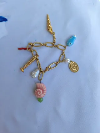Pulsera dorada con colgantes marinos
