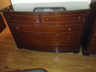 Cómoda de madera con tapa de cristal.