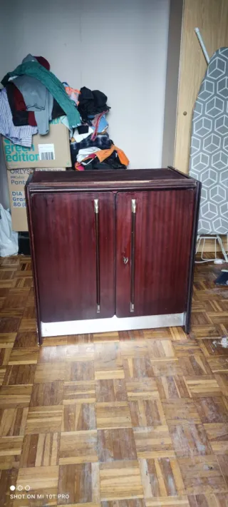 Mueble de madera con puertas y base metálica.