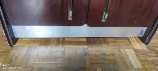 Mueble de madera con puertas y base metálica.