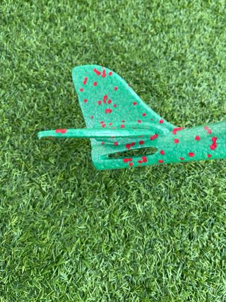 Avión de corcho verde con puntos rojos