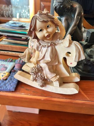 Figura niña con caballo balancín