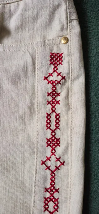 Pantalón beige con bordado rojo