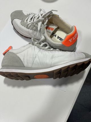 Zapatillas Bimba y Lola blancas y logo naranja.