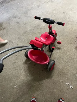 Triciclo rojo con manillar y cinturón