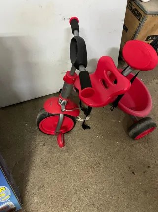 Triciclo rojo con manillar y cinturón