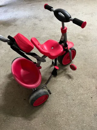Triciclo rojo con manillar y cinturón