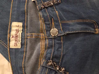 Jeans donna con strass e dettagli in metallo