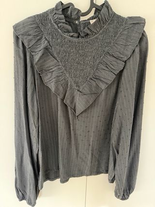 Blusa gris con volantes y cuello alto