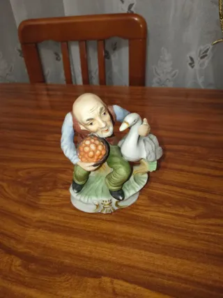 Figura de porcelana de anciano con ganso