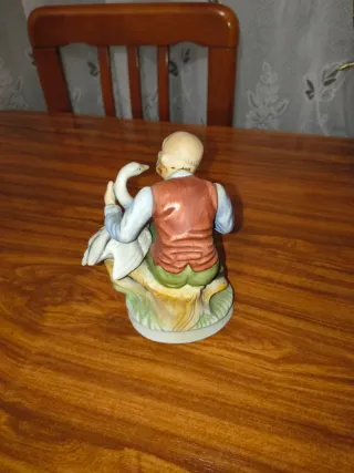 Figura de porcelana de anciano con ganso