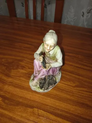 Figura de porcelana anciana con peces